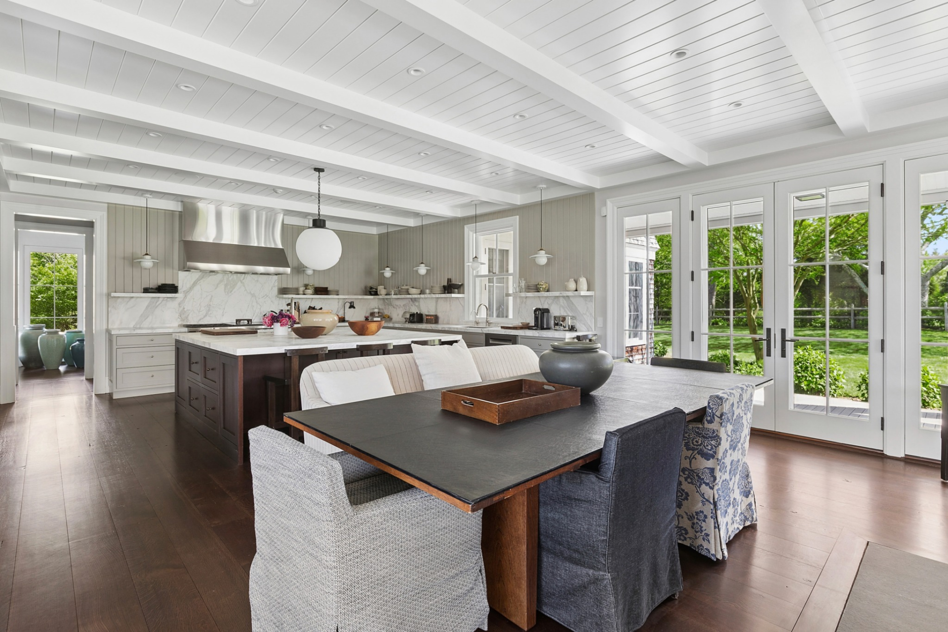 A large dark wood table provides seating for gatherings, while a built-in fireplace and nearby sitting area create a more relaxed atmosphere than a formal dining room.