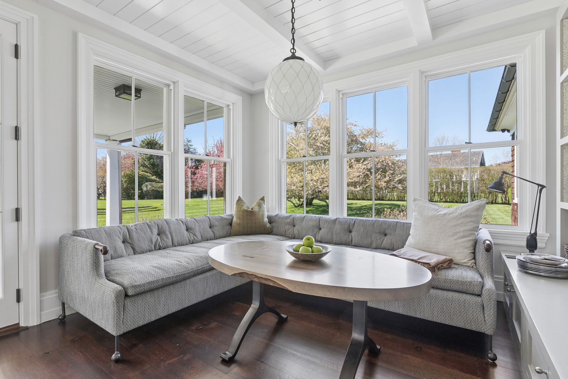 Tucked into a bright corner, the breakfast nook features a wraparound banquette that maximizes seating around an oval table.