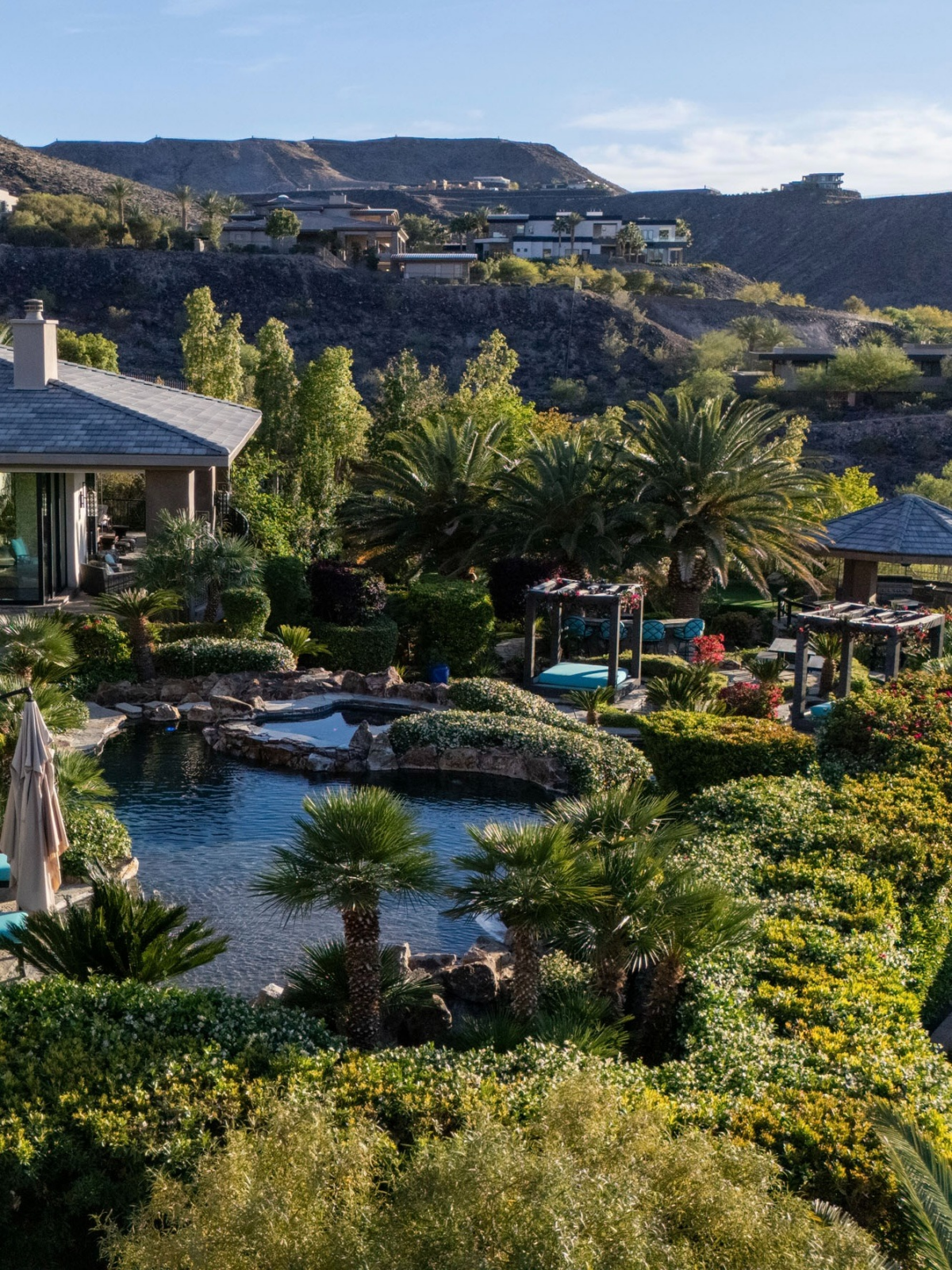 At the center of the grounds are two lagoon-style pools connected by natural stone elements and surrounded by resort-inspired landscaping.