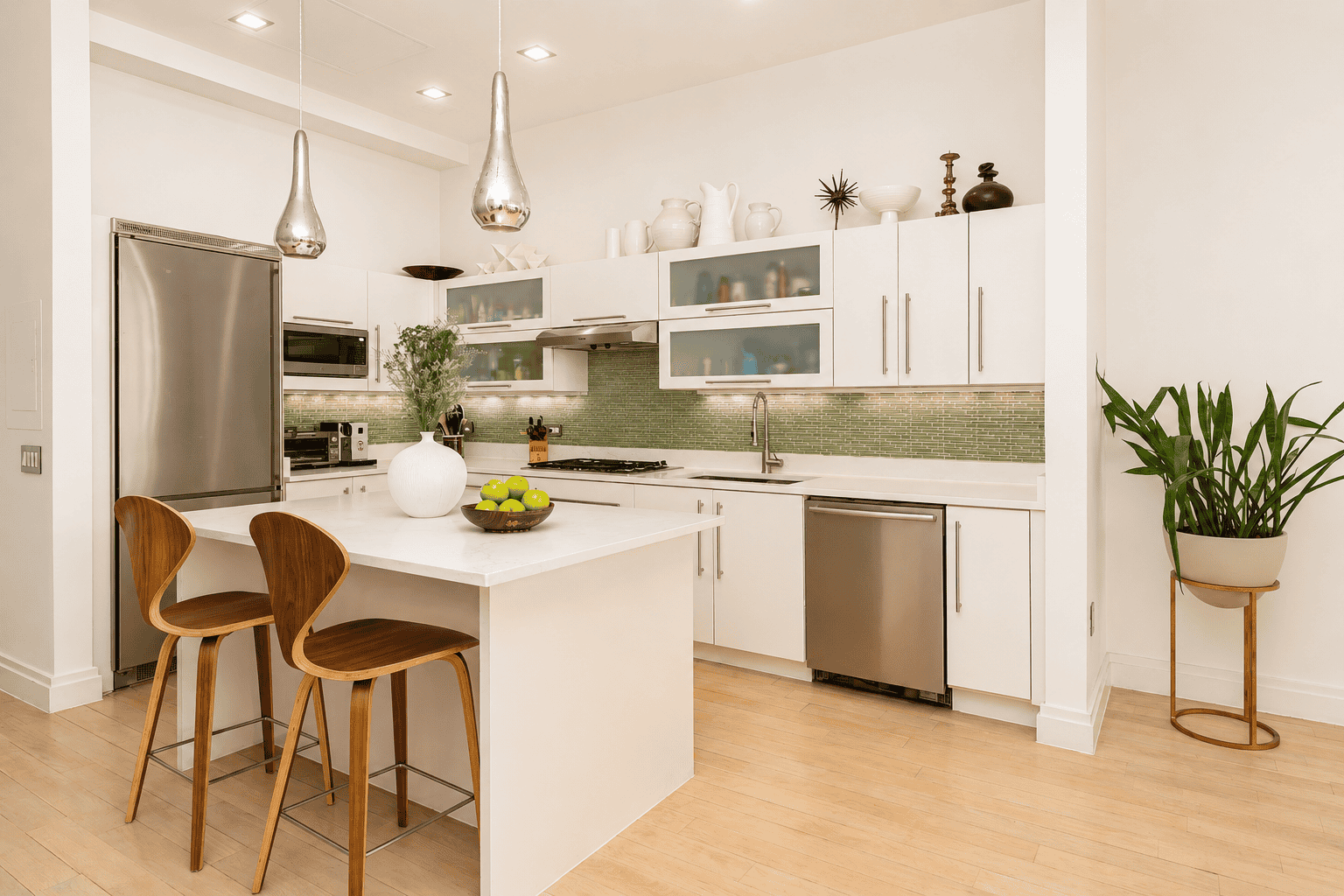 Quartz countertops and white custom cabinetry line the corner placement, maximizing storage, while integrated appliances blend into the design for a streamlined appearance.