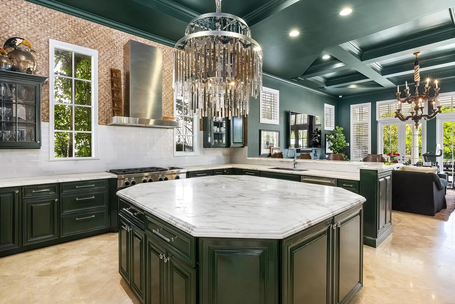 An oversized center island centers the room, providing extensive prep space as well as additional storage, while a raised breakfast bar offers seating for casual meals. 