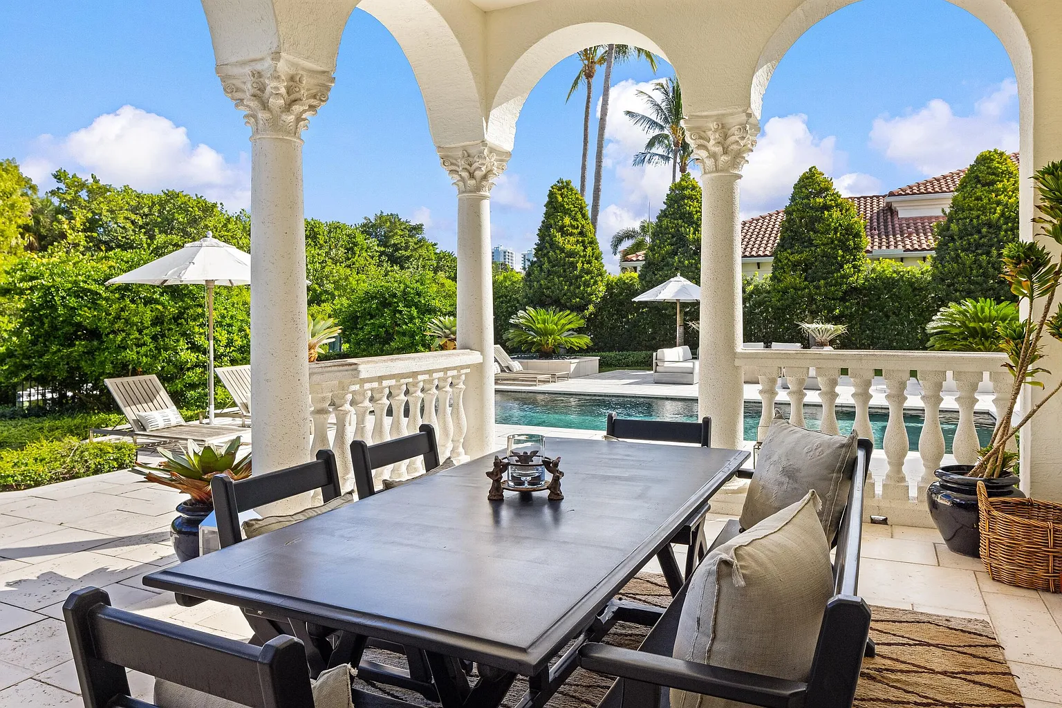 Arched openings and stone columns frame views of the pool while providing shade from the Florida sun. 