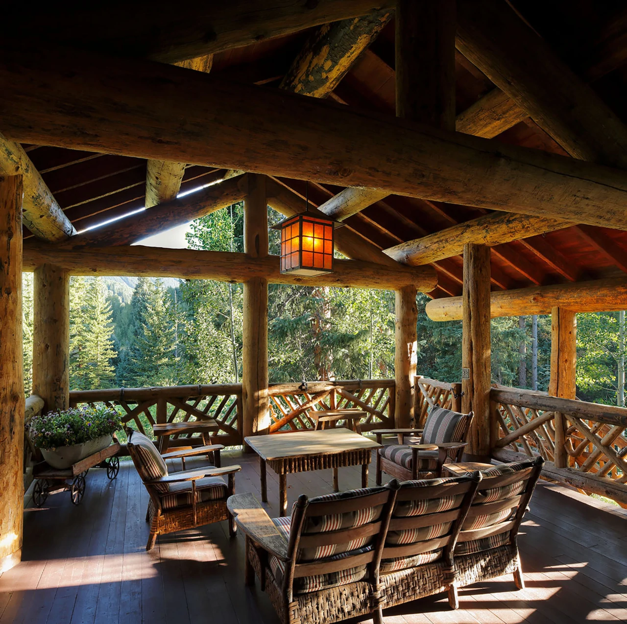 Seating areas are arranged beneath the vaulted timber roof of an outdoor patio.