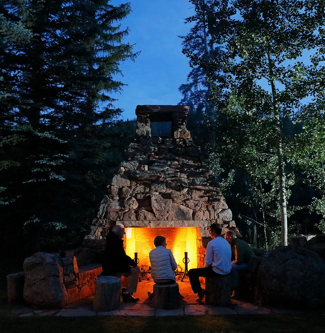 Massive stone firepit surrounded by natural seating.