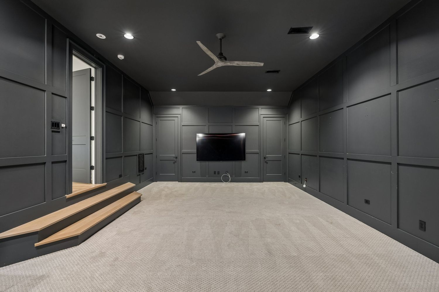 The space is large enough to accommodate multiple rows of seating and is centered around a wall-mounted screen for movie nights and game-day viewing. 