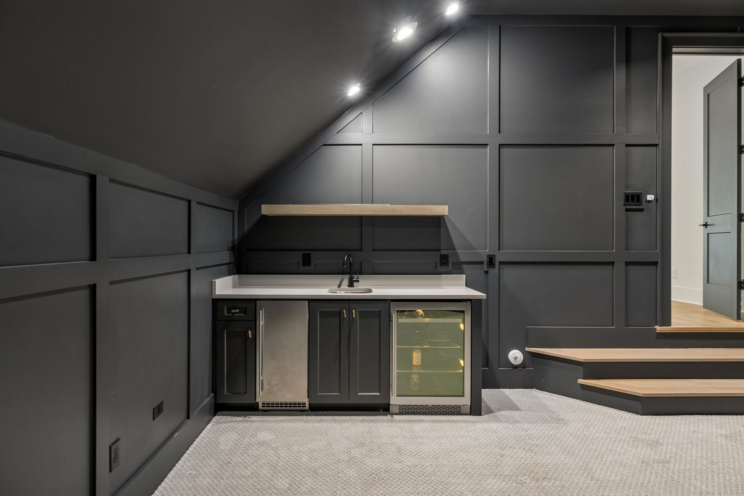 Just off to the side, a built-in wet bar with a sink, beverage refrigerator, and cabinetry allows snacks and drinks to be served without leaving the room.