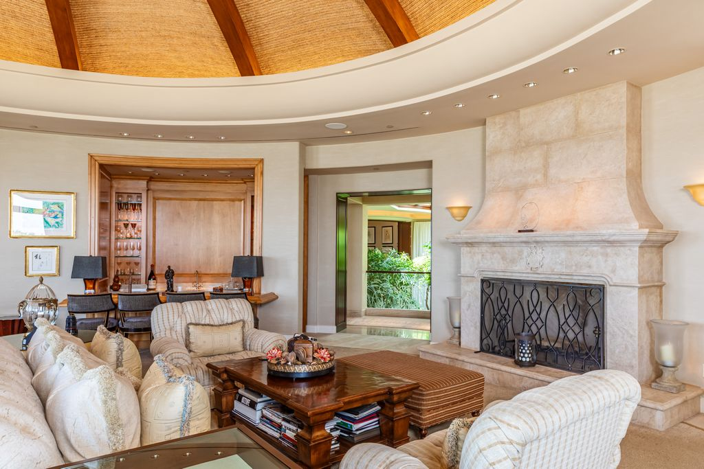 Multiple seating arrangements are organized around a stone fireplace.