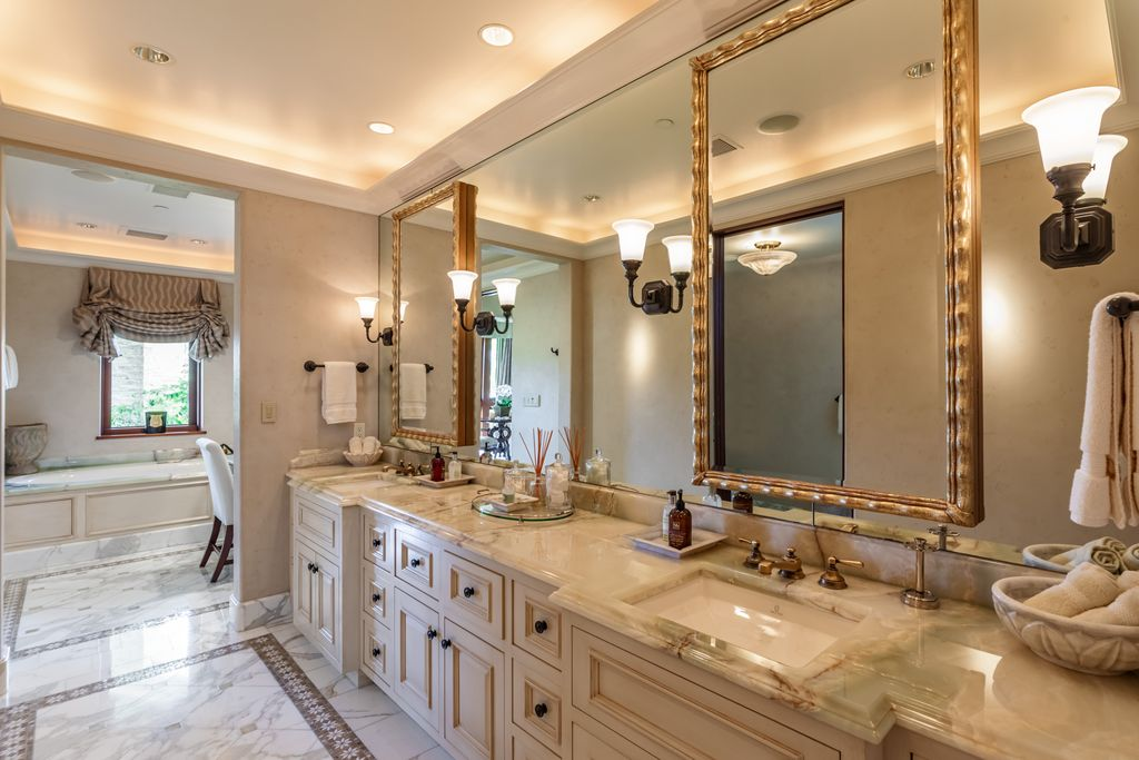 A long dual-sink vanity stretches beneath oversized framed mirrors, providing ample storage and counter space.