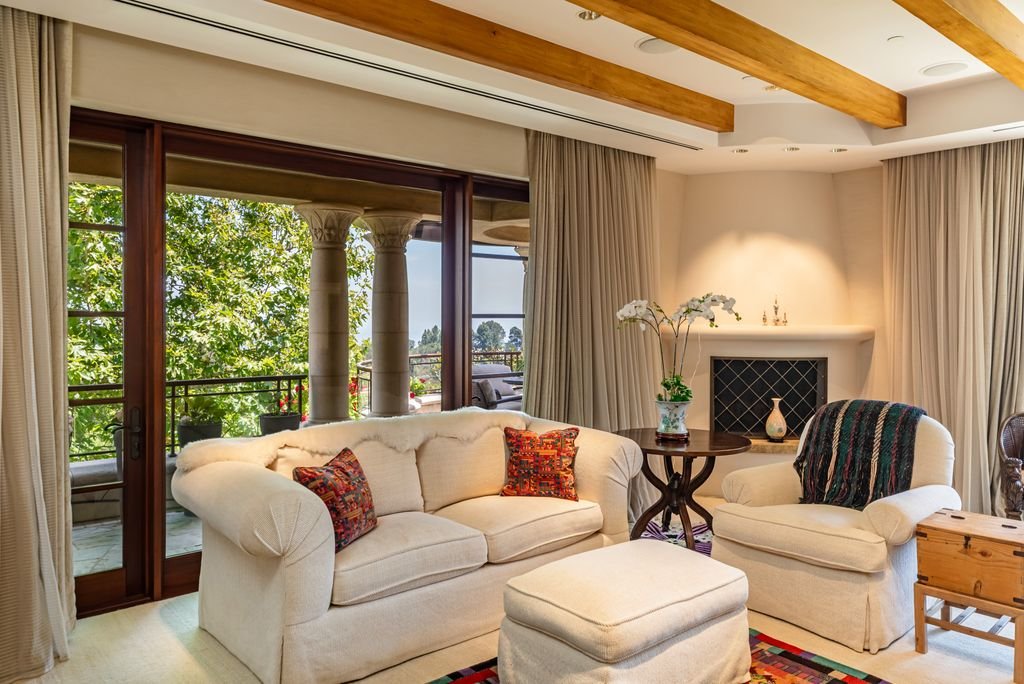 At one end of the suite, a dedicated lounge is arranged around a fireplace, creating a second living space in front of the private balcony.
