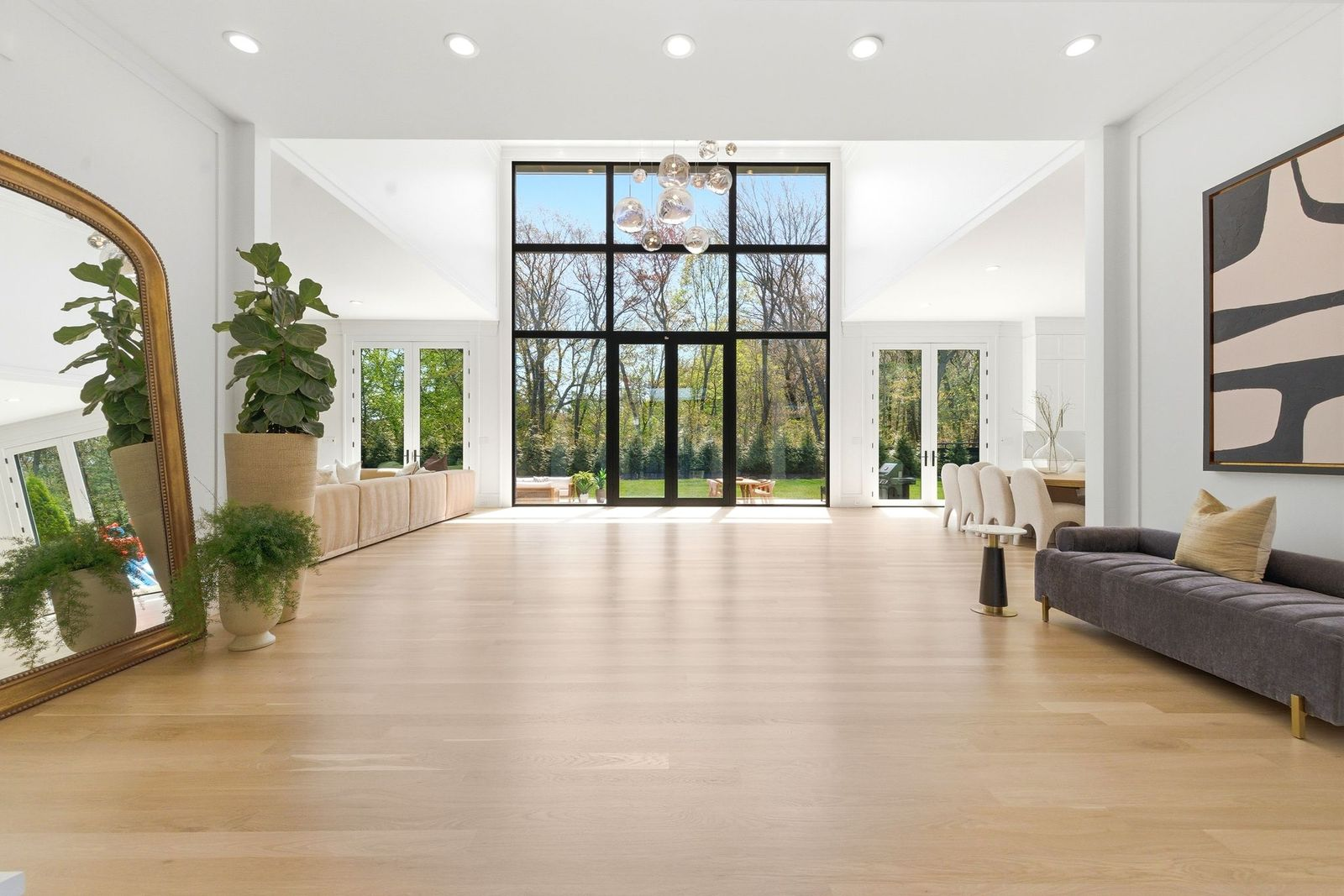 Just past the entrance, the home's main living spaces spread out across light wood flooring, starting with a simple lounge.