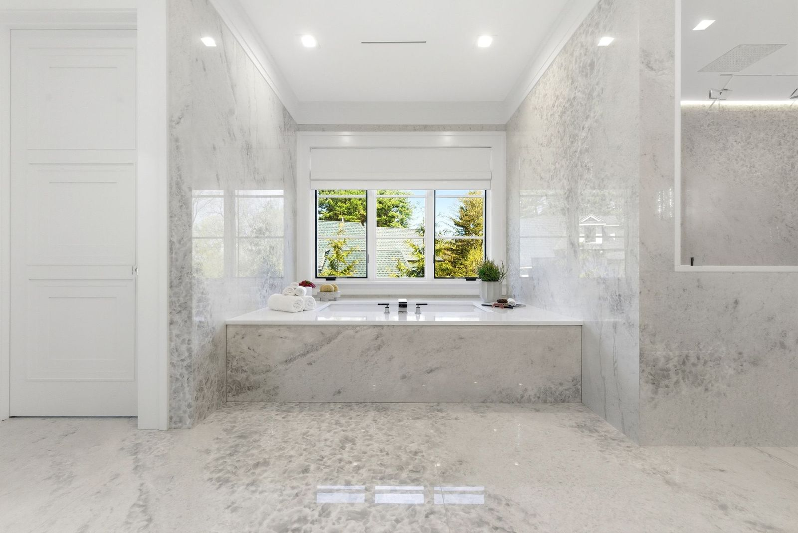 Finishing off the bathroom just past the shower, a soaking tub sits beneath a large window that overlooks the surrounding greenery.