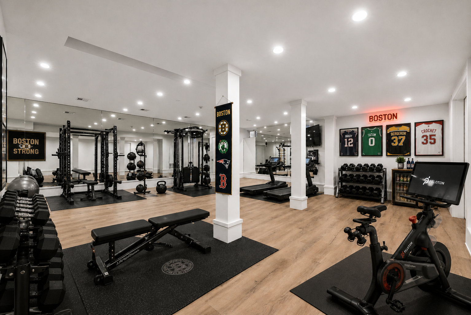 A full power rack, cable machine, free weights, kettlebells, and benches provide everything needed for weight training, while multiple treadmills and a Peloton bike create cardio sections.