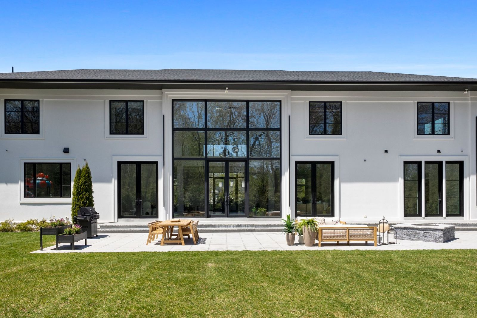A dining table, built-in grilling station, seating area, and firepit provide the essentials for entertaining.
