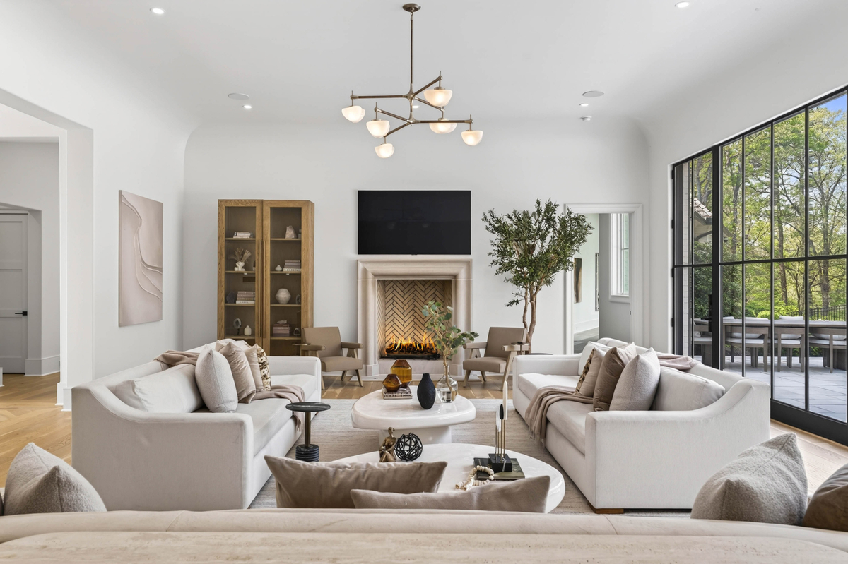 In the center, multiple sofas are arranged around a pair of sculptural coffee tables, creating several conversation areas without interrupting the room's open flow.