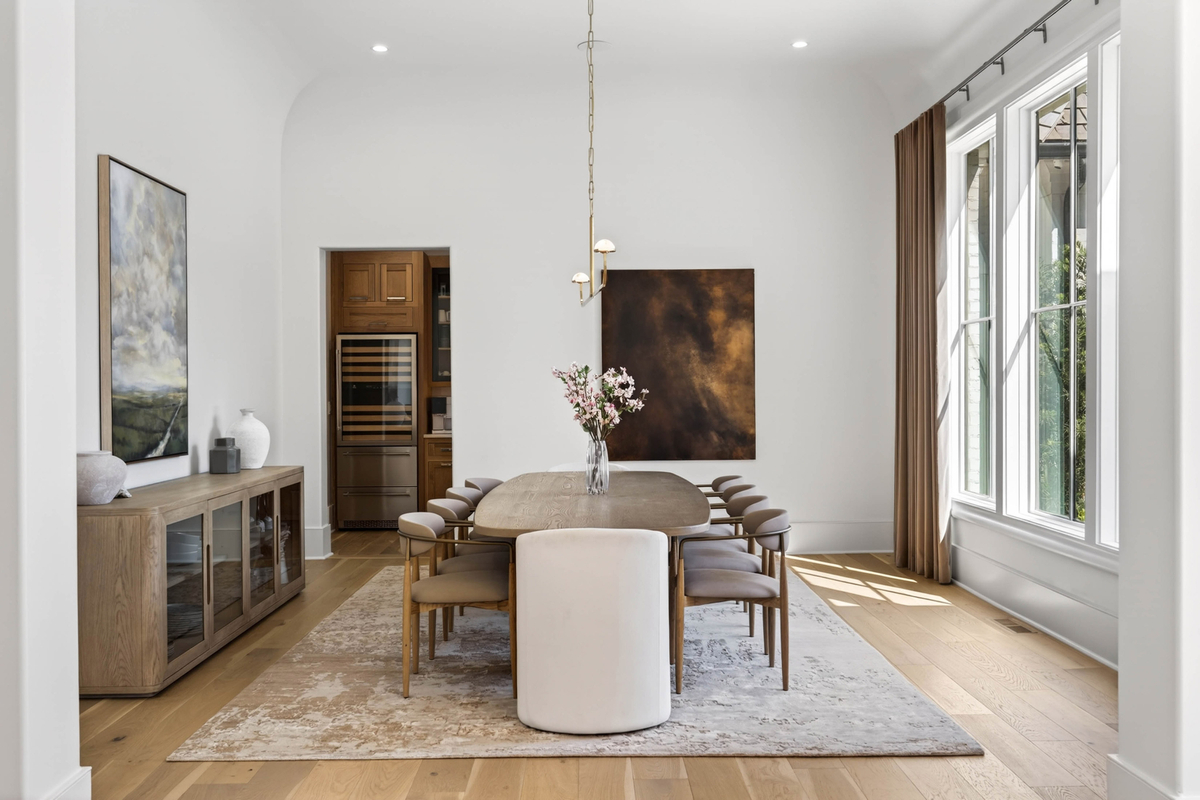 The formal dining room, a dedicated space designed for larger gatherings around a long wood dining table surrounded by upholstered seating.