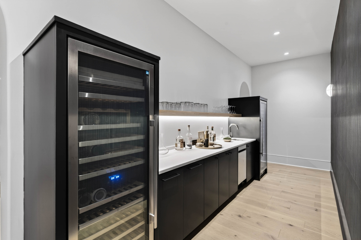 Connected to the kitchen is a full bar area with beverage refrigeration, storage, and serving space.
