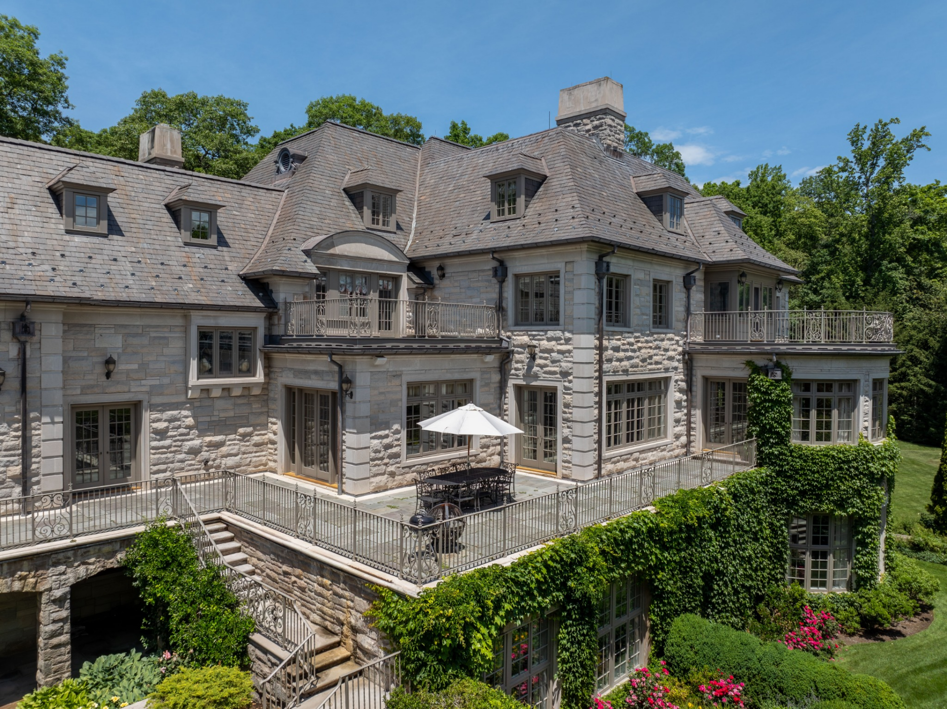 A series of stone terraces wraps around the back of the residence, creating several outdoor gathering areas across different elevations.
