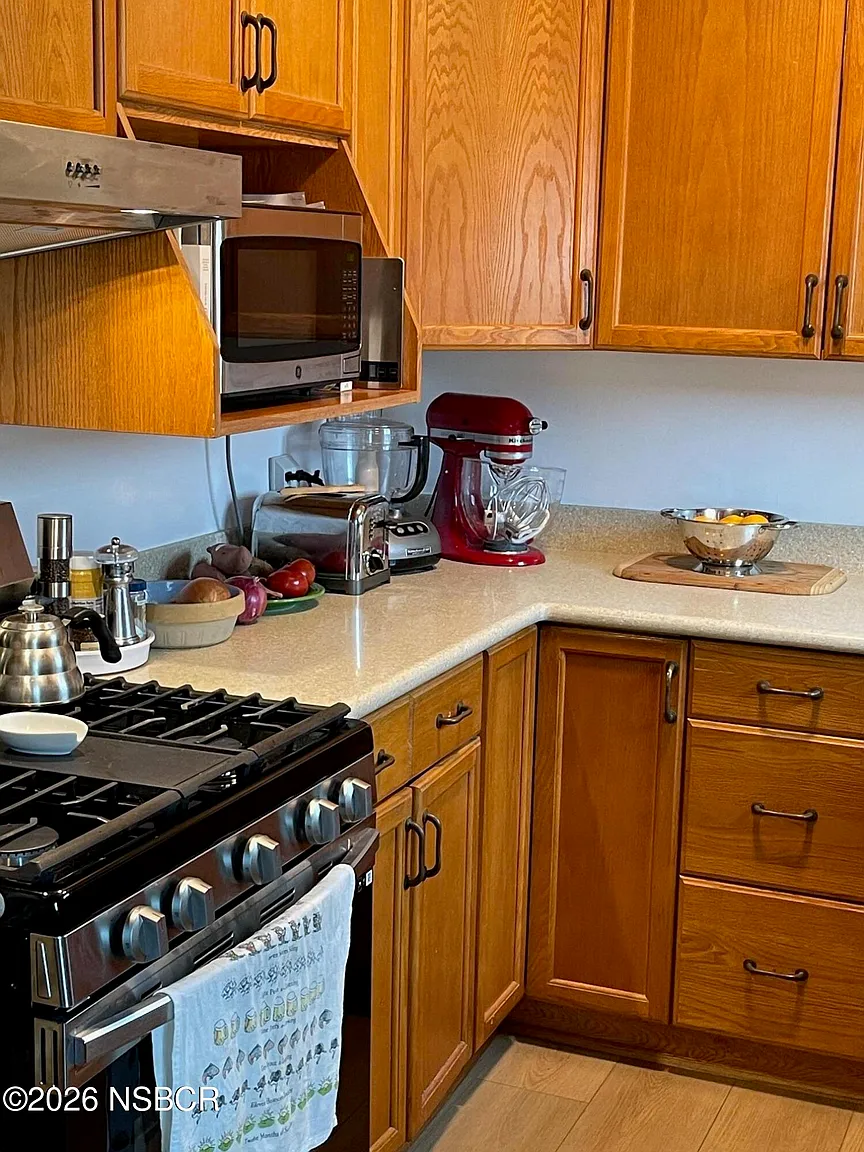 A professional-style gas range is accompanied by space for everyday appliances, while the open countertop is reserved for cooking essentials and fresh produce.