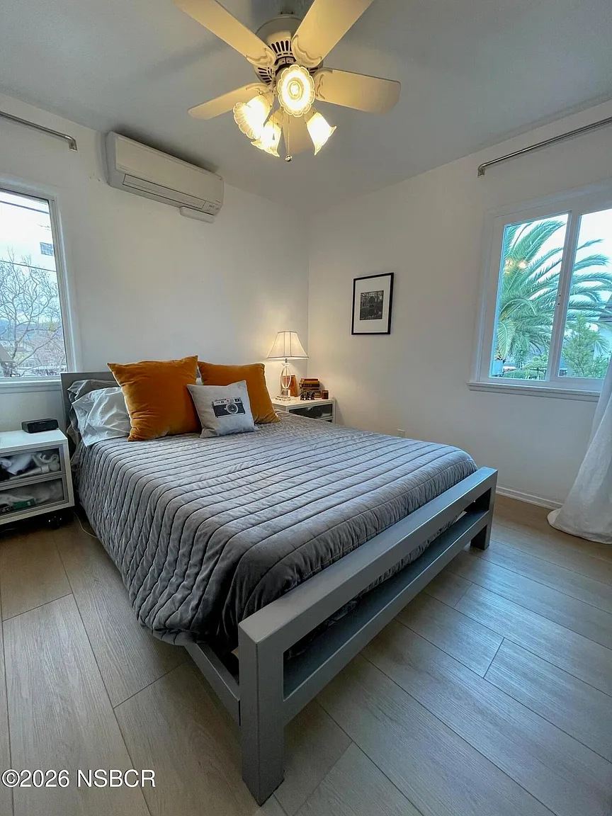 The second bedroom takes on a more contemporary look with a gray platform bed, neutral bedding, and minimalist furnishings.