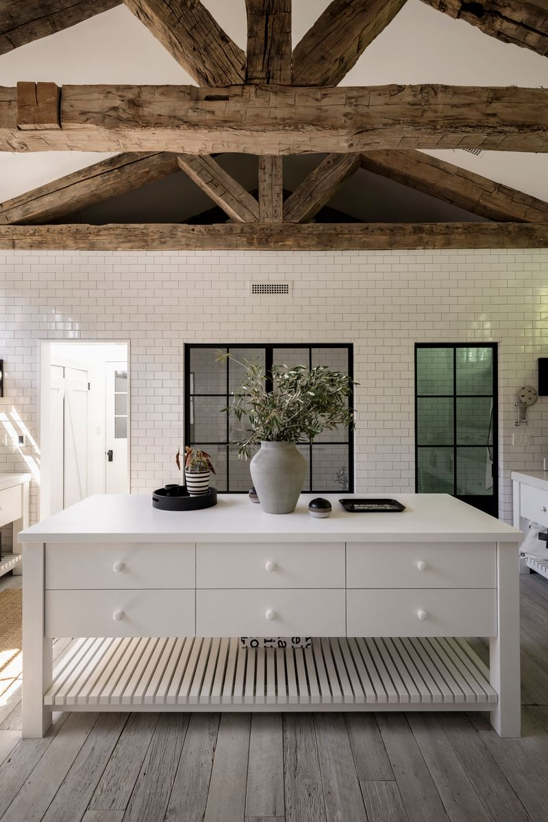 Inside the suite's bathroom, a large central island provides storage space, and matching vanities are placed on opposite ends of the room.