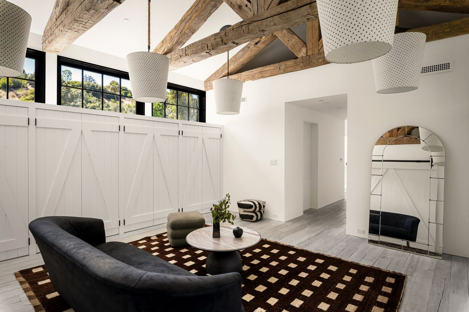 Completing the suite is a spacious dressing room organized around a series of floor-to-ceiling barn-style cabinets.