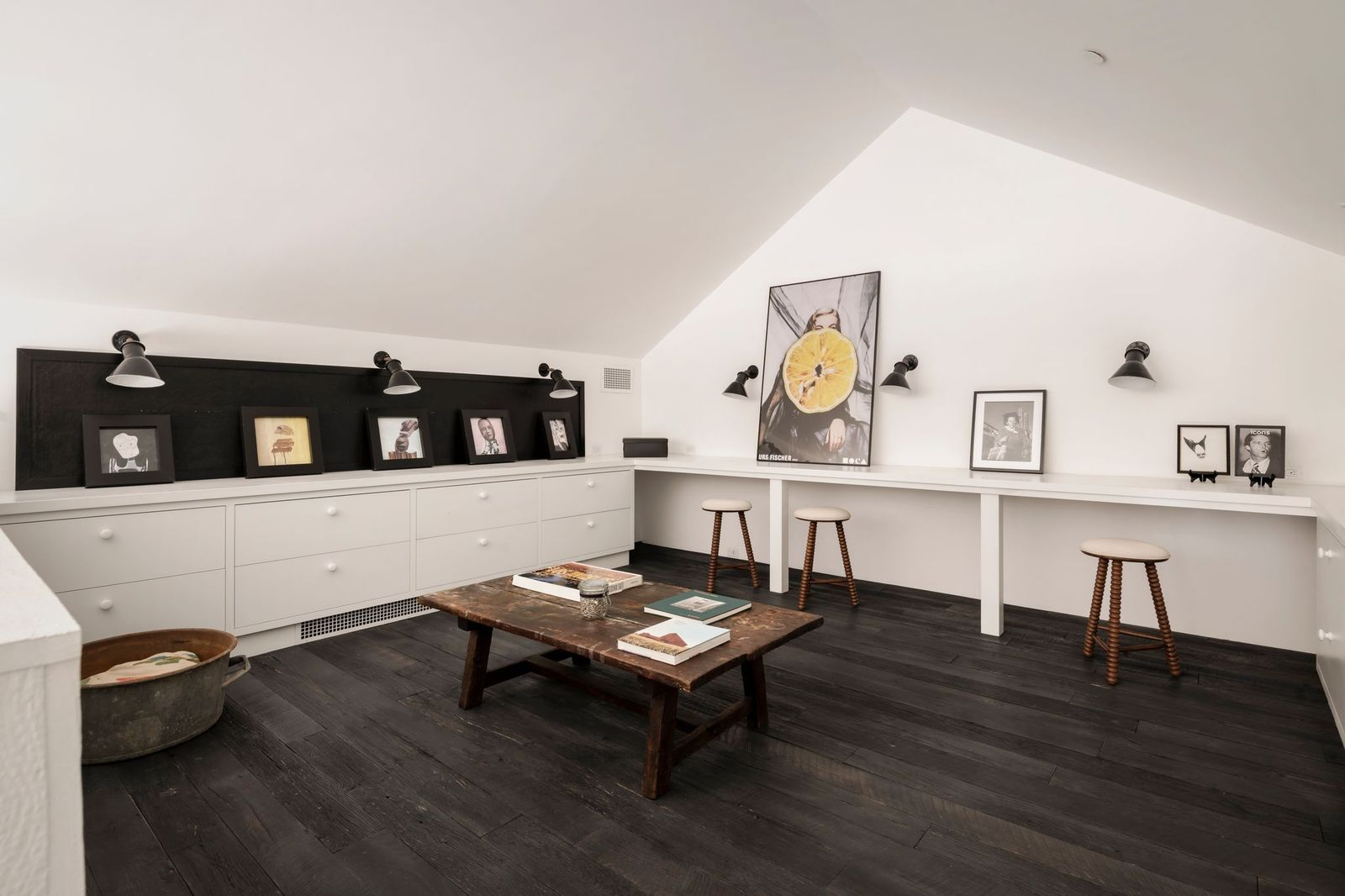 An upstairs loft has been fitted with long built-in work counters, storage cabinetry, and seating for collaborative projects.