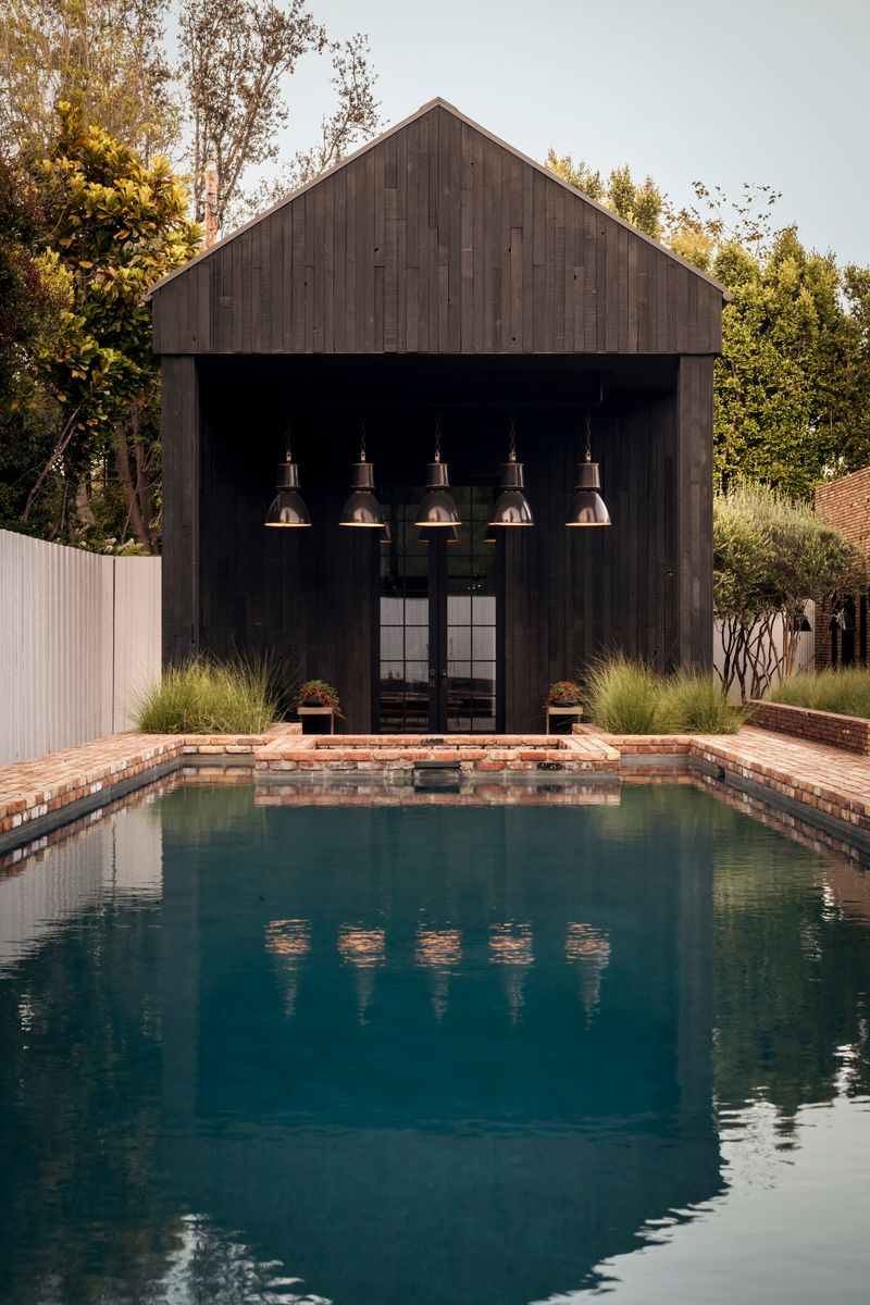Just outside the guest house, the backyard centers around a long rectangular pool and raised spa.