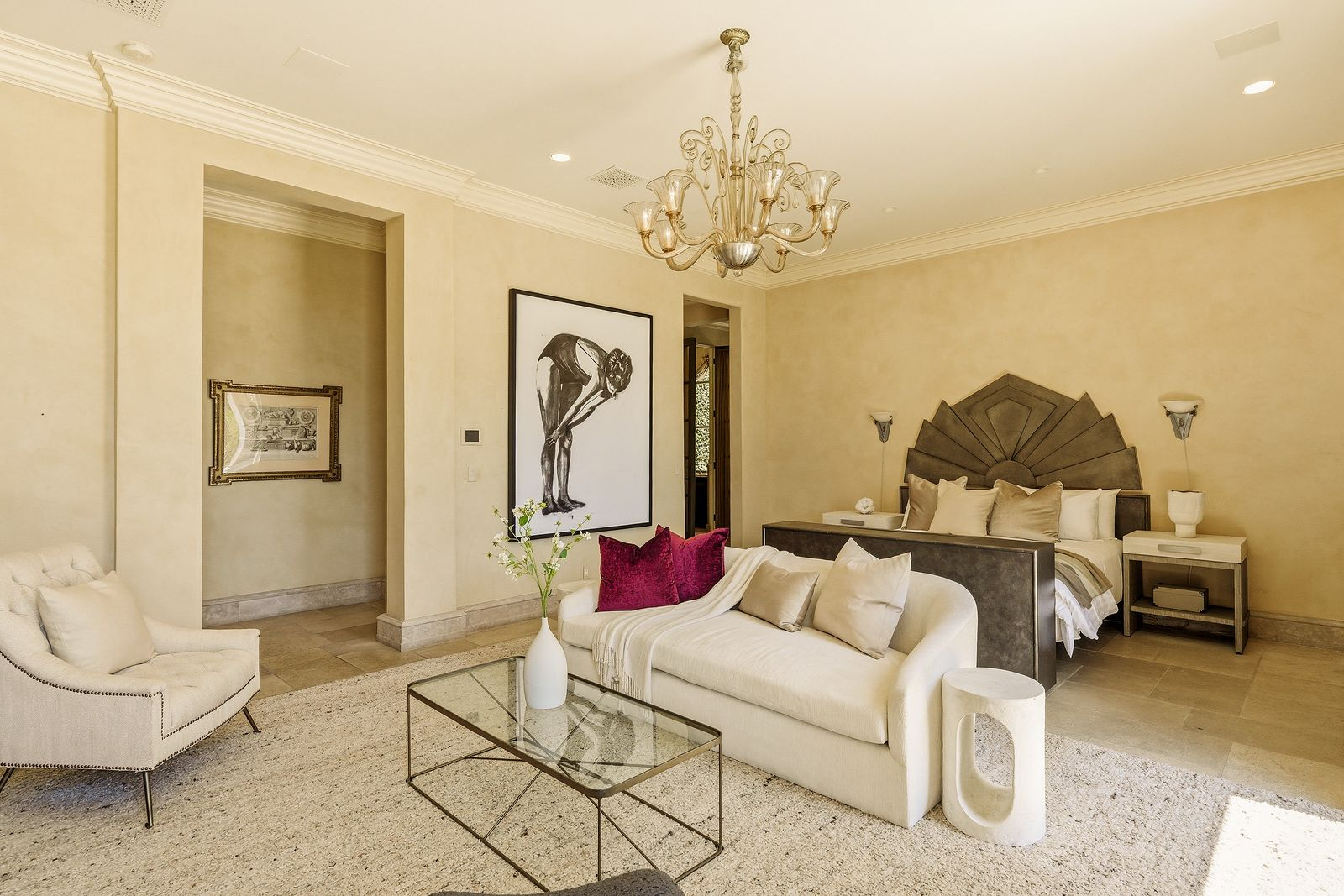 The primary suite opens up with a bedroom that features a sculptural bed, a fireplace, and a lounge.