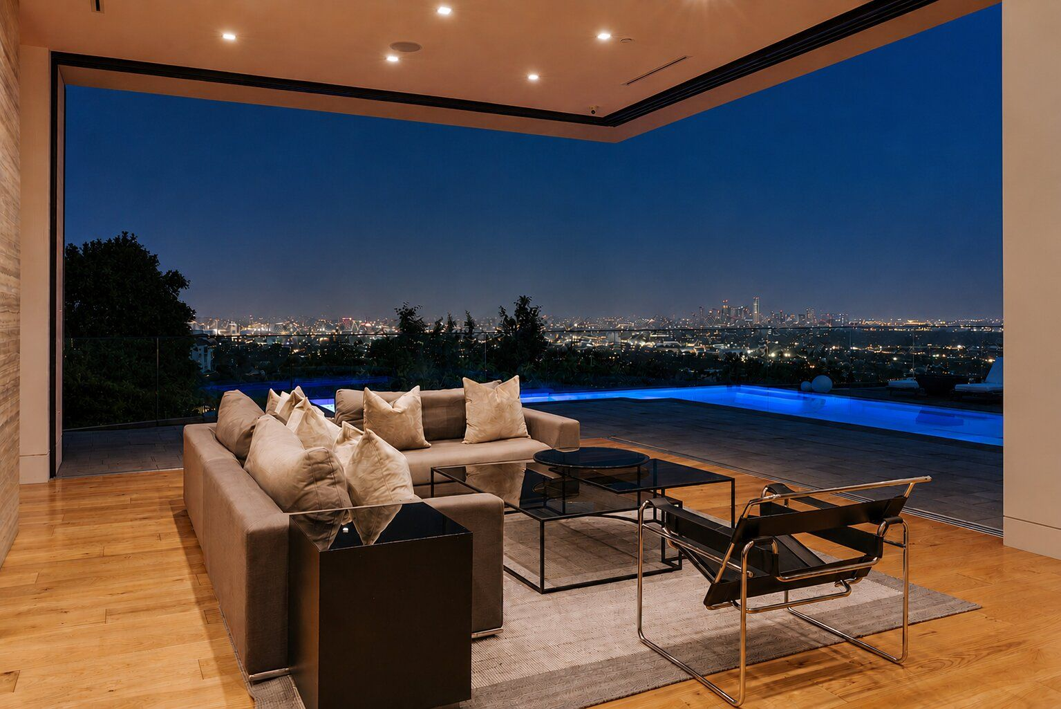 Low-profile seating is positioned to face the home's views in a corner of disappearing glass walls.
