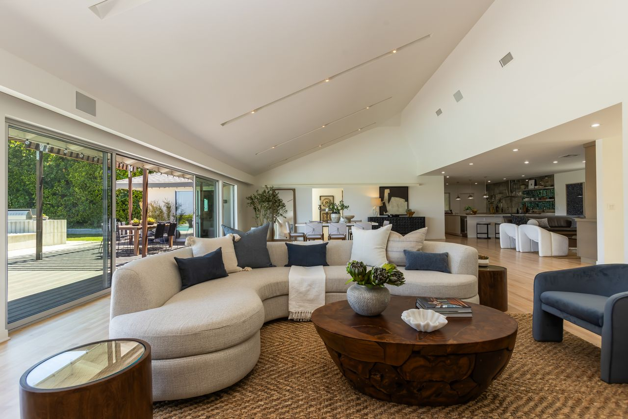 Curved seating, light wood floors, and minimalist furnishings give the space a relaxed feel.