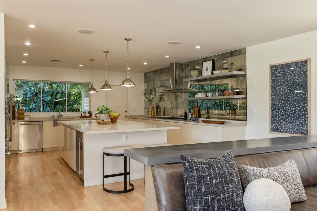 A large Caesarstone island provides ample workspace and casual seating in the center of the kitchen.