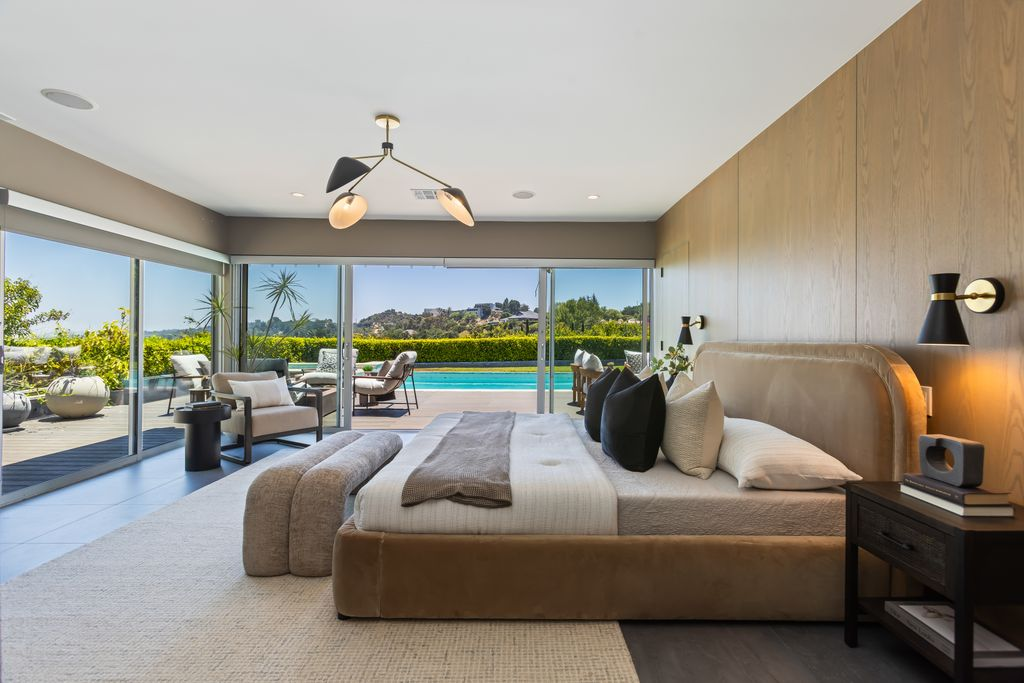 Expansive sliding glass doors open directly onto the pool terrace from the bedroom.