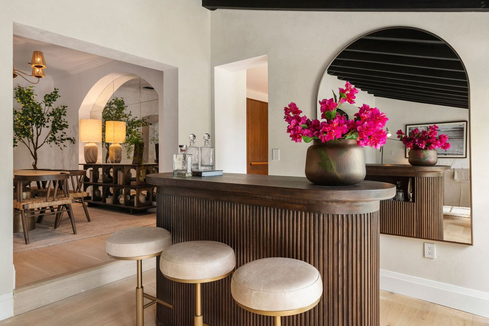 At one end of the lounge, a custom fluted wood bar with a rounded profile provides seating for three.