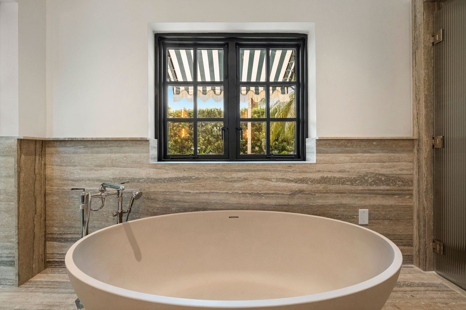 Placed below a large window overlooking the gardens is a freestanding soaking tub.
