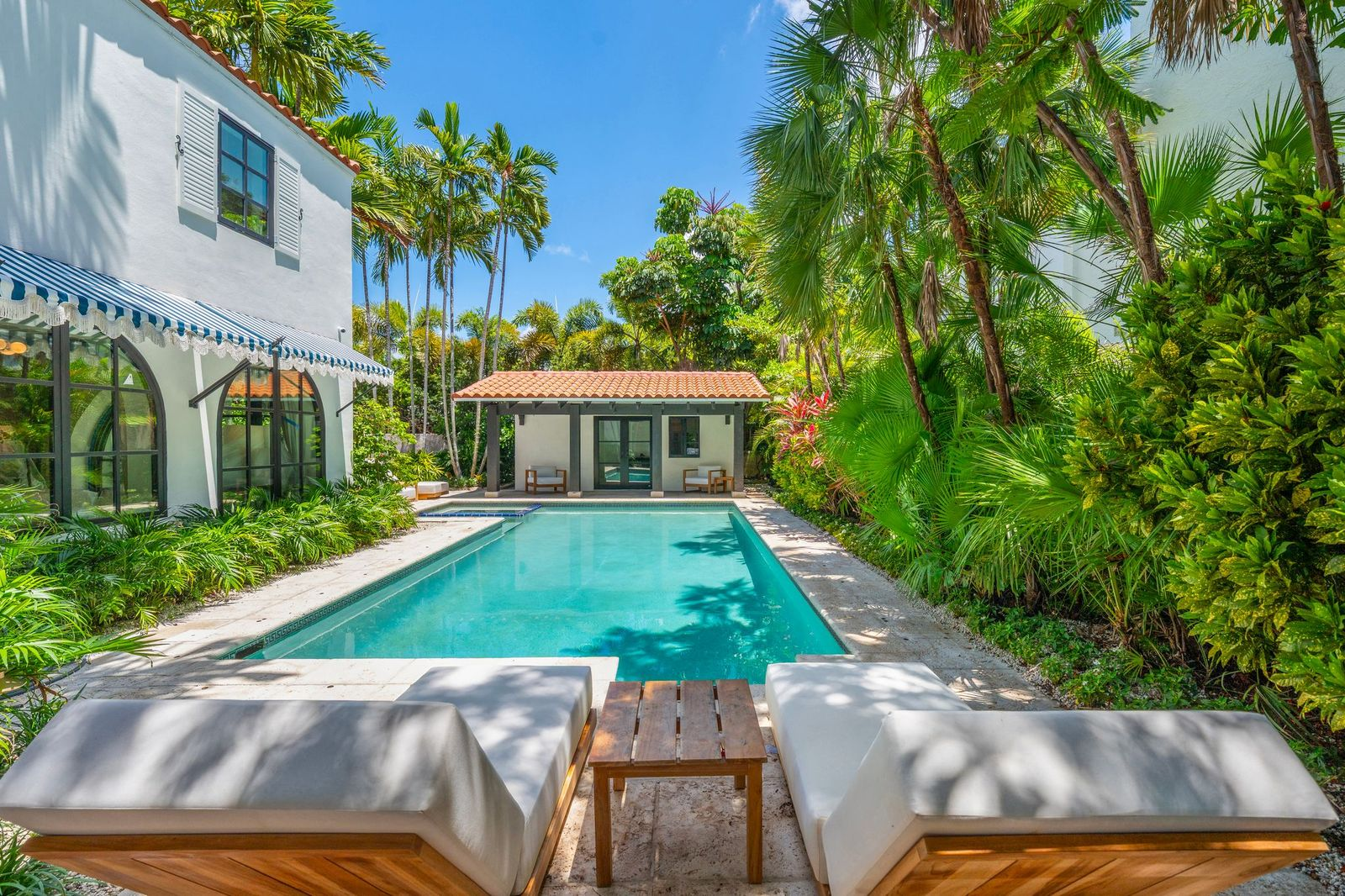 Stone decking wraps around the water with space for loungers along each end.