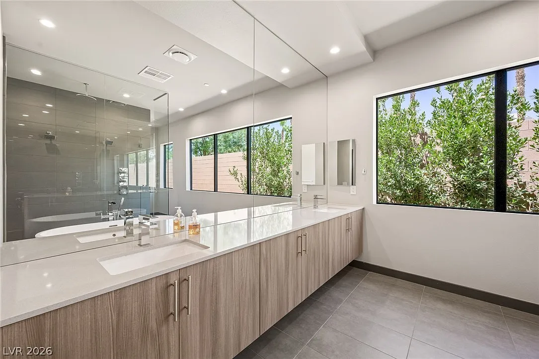A long dual-sink vanity with extensive storage and full wall mirror.