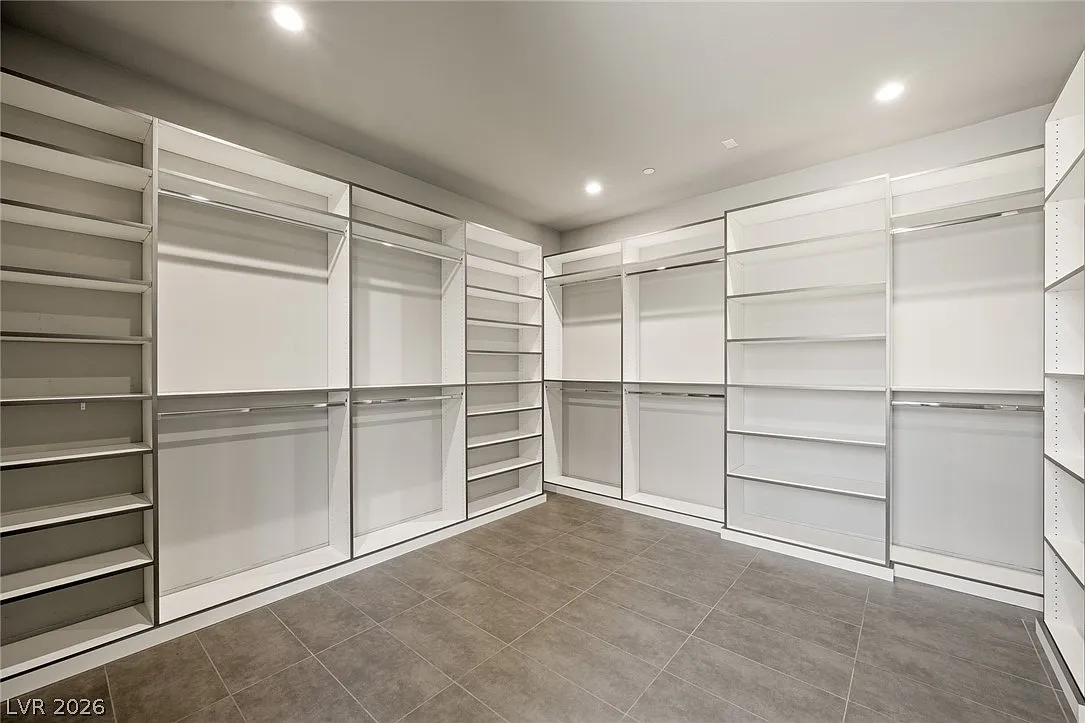 The oversized walk-in closet is built with custom shelving, hanging sections, and open storage that wraps around nearly every wall.