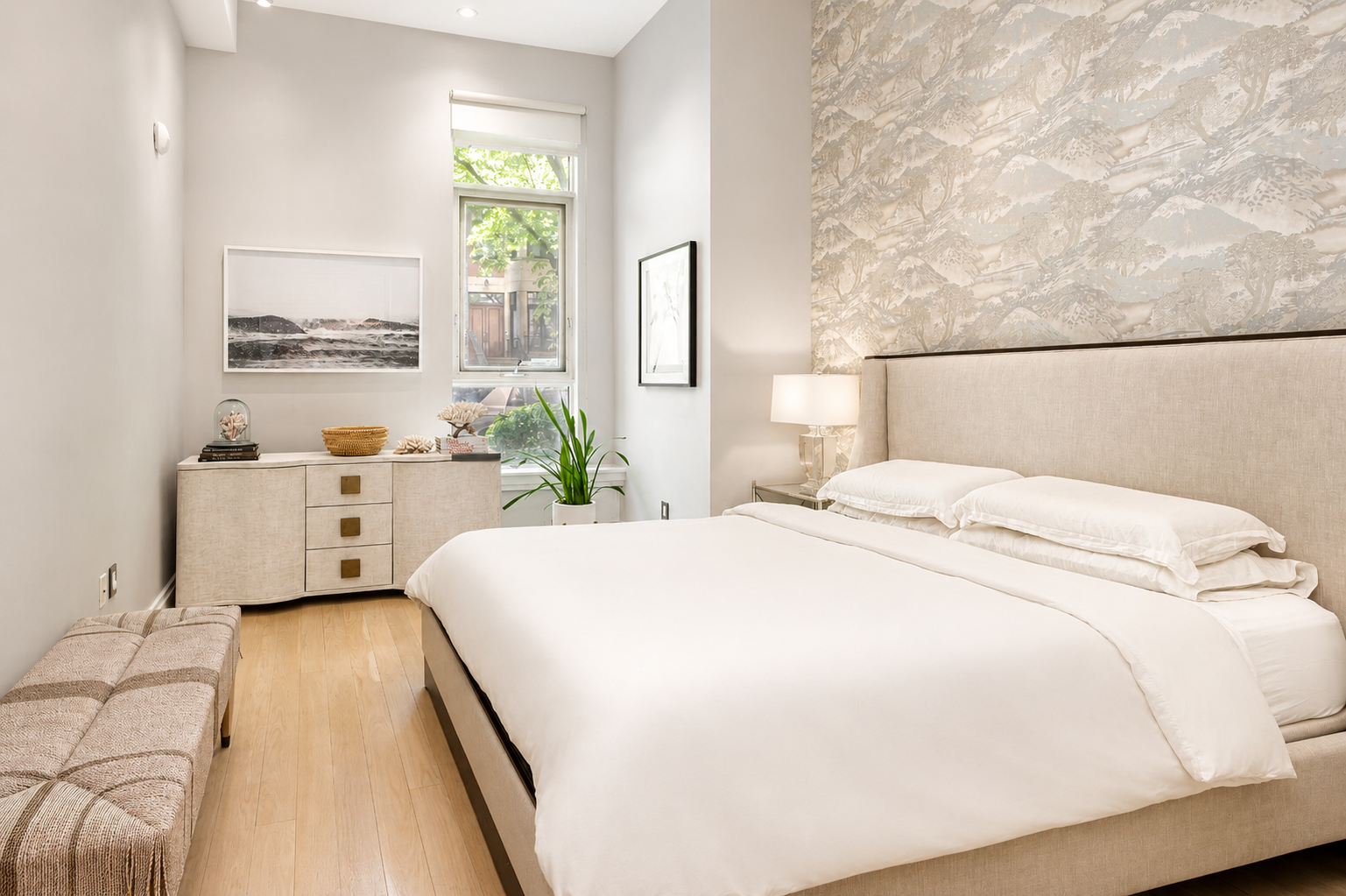 The suite takes advantage of the home's generous ceiling heights, creating an airy atmosphere enhanced by a tall window that brings in natural light.