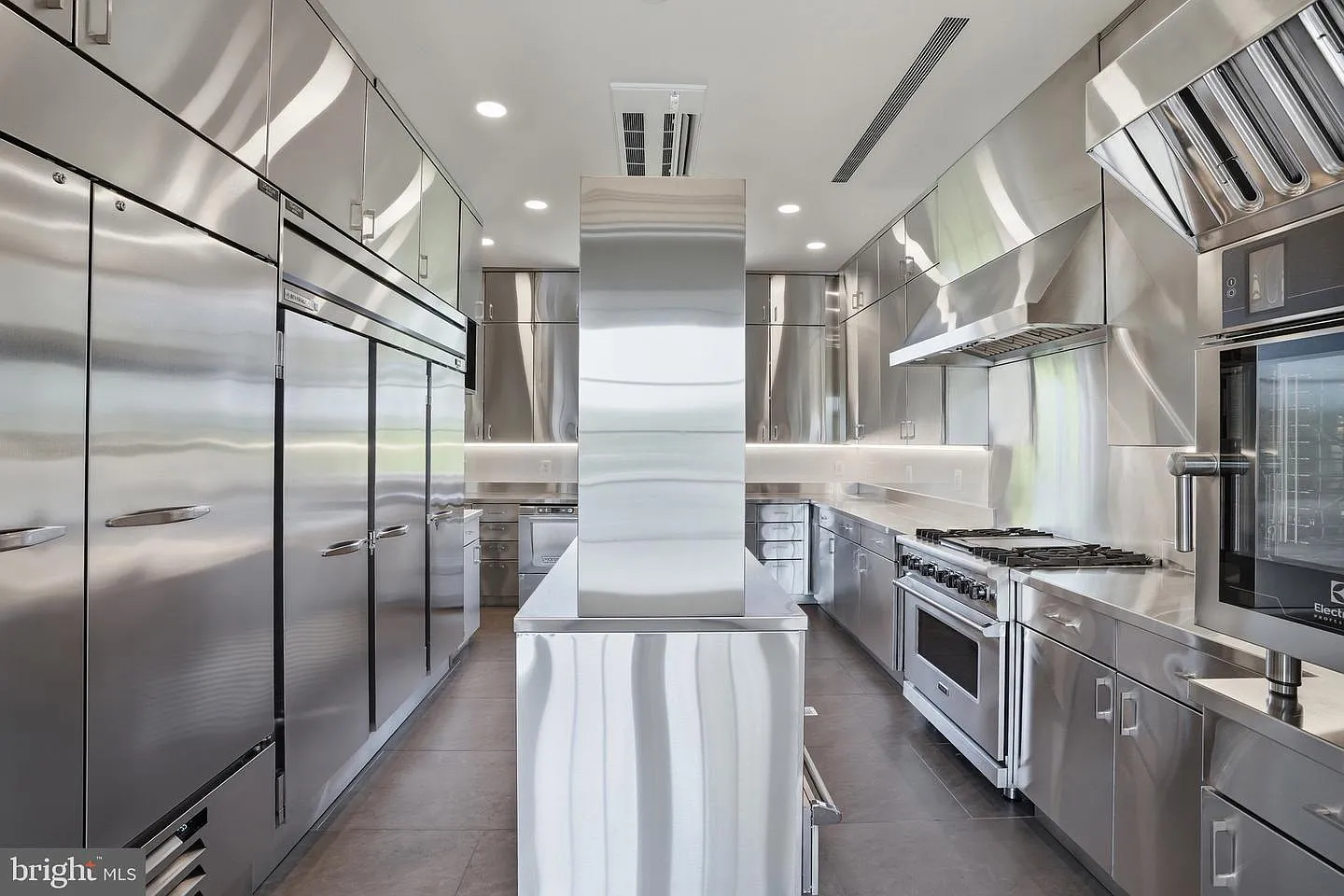 This space takes a distinctly professional approach, with stainless-steel surfaces covering nearly every wall, cabinet, and work area.