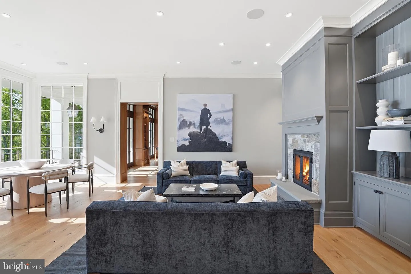 A stone fireplace anchors one side of the room, while a comfortable seating arrangement creates a central area for everyday living.