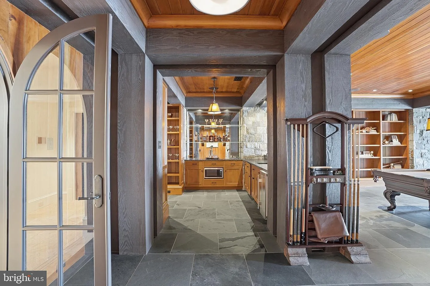 Opening up the main entertaining area is a full-service bar finished with handcrafted stonework and rich wood detailing. 