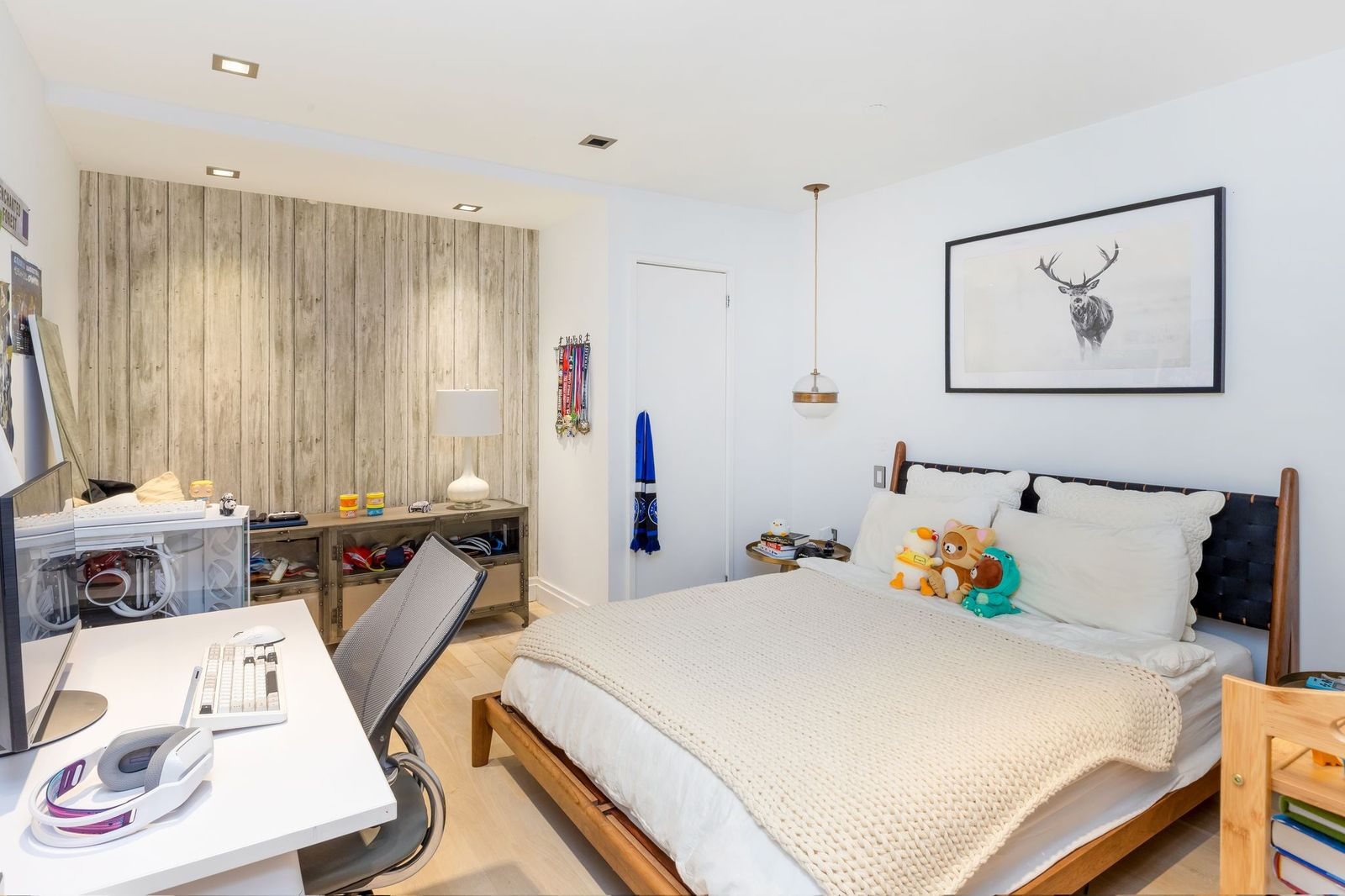 One of the lower-level bedrooms combines a sleeping area with a dedicated workspace across from the bed.