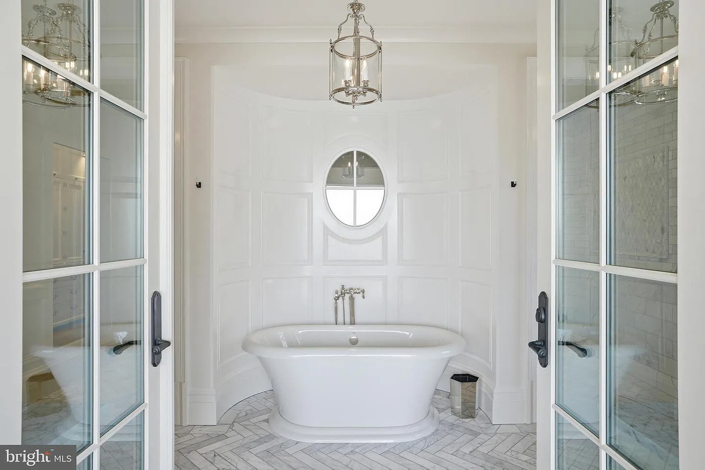 On the other side of the bathroom, a freestanding soaking tub is positioned within its own paneled alcove.