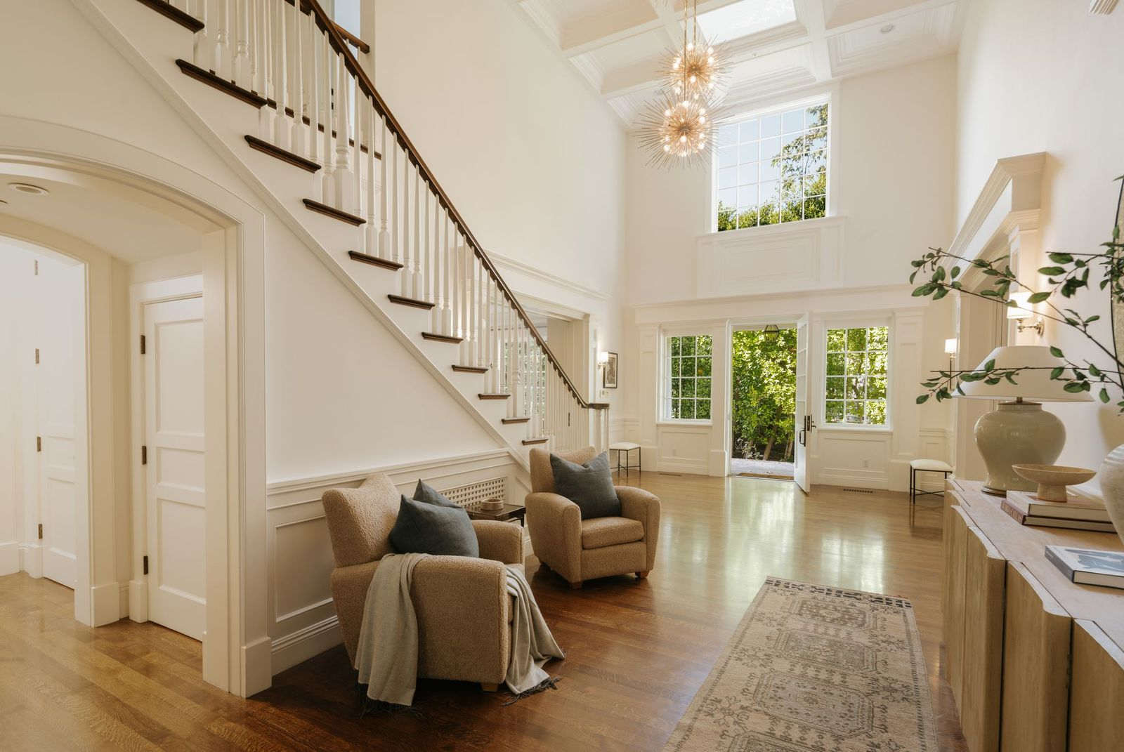 Natural light plays a major role throughout the interiors, filtering through large windows and glass doors that connect many of the rooms to the surrounding grounds.