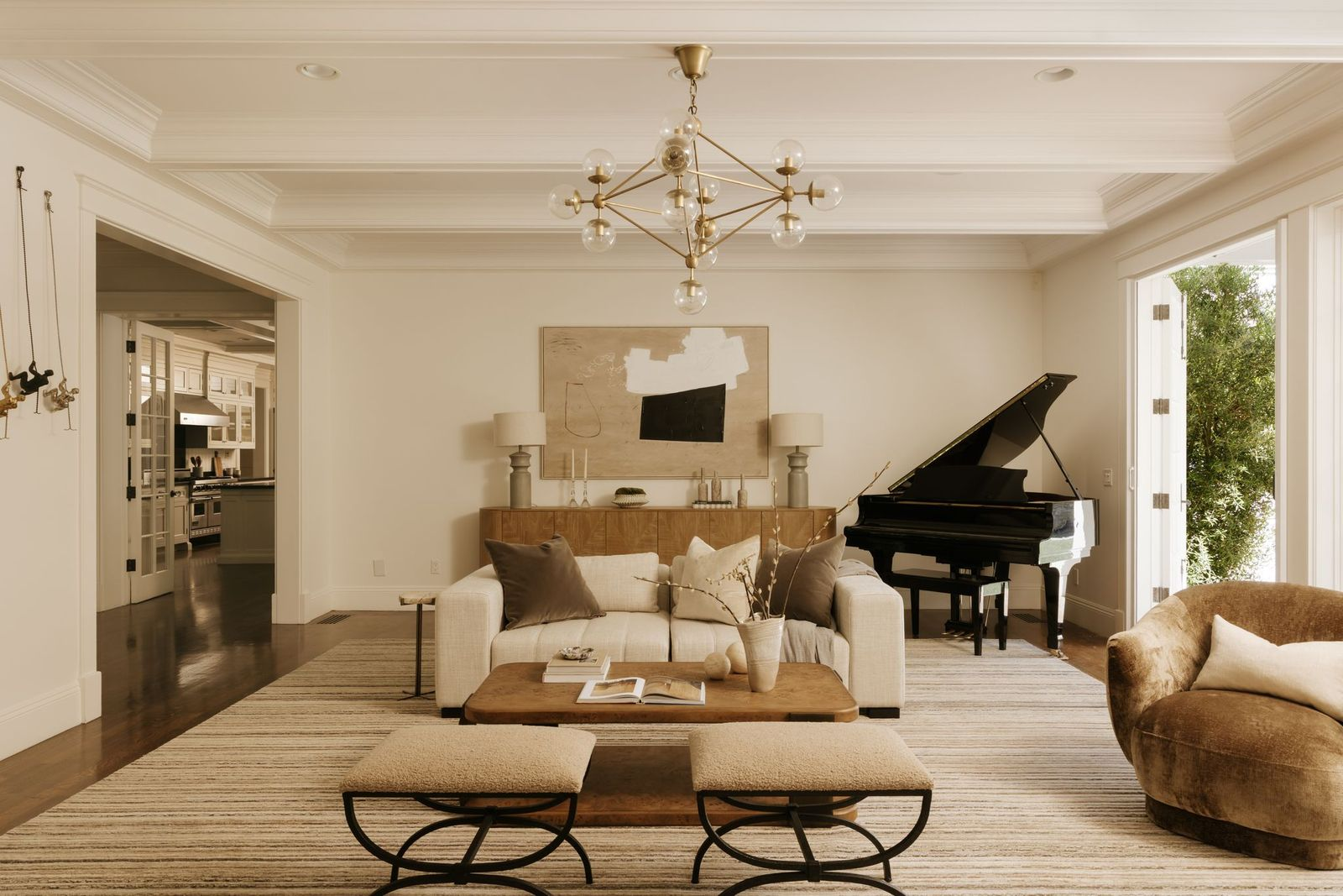 The room's neutral furnishings, warm wood accents, and layered textures create a relaxed atmosphere that feels approachable despite the home's scale.