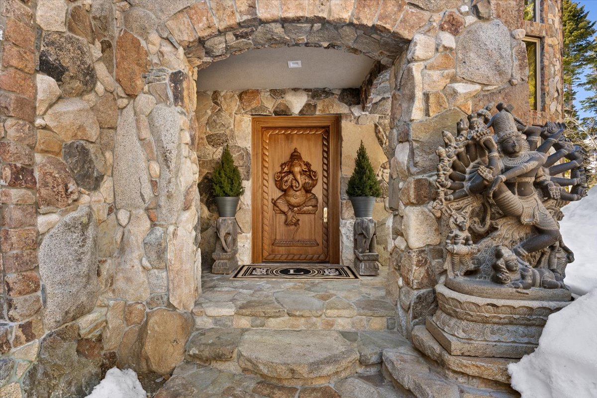 A hand-carved temple door commissioned from artisans in southern India, complete with intricate carvings and a ruby inlay at its center.