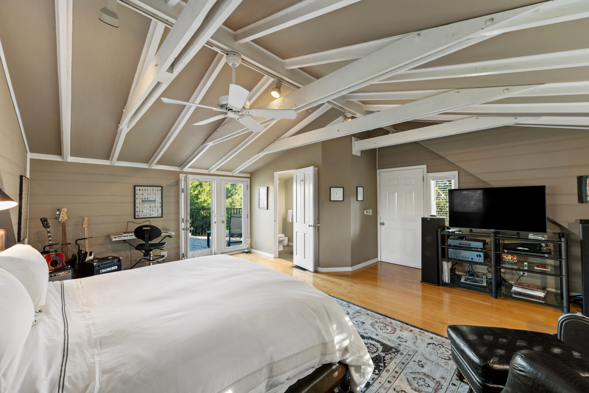French doors even open to a balcony overlooking the surrounding trees.