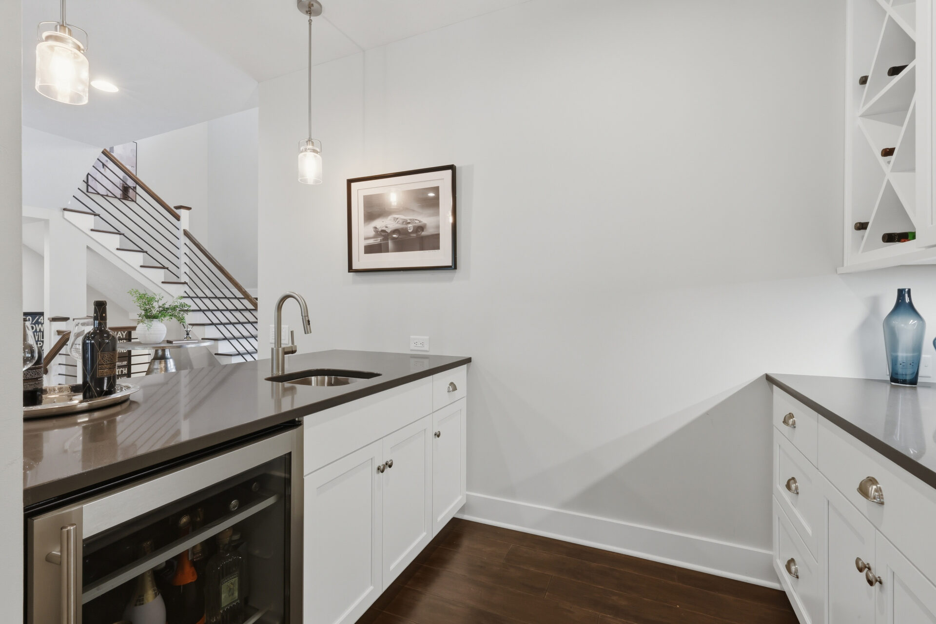 Tucked into the corner, a built-in wet bar provides a convenient spot for serving drinks without interrupting the flow of the main gathering spaces. 