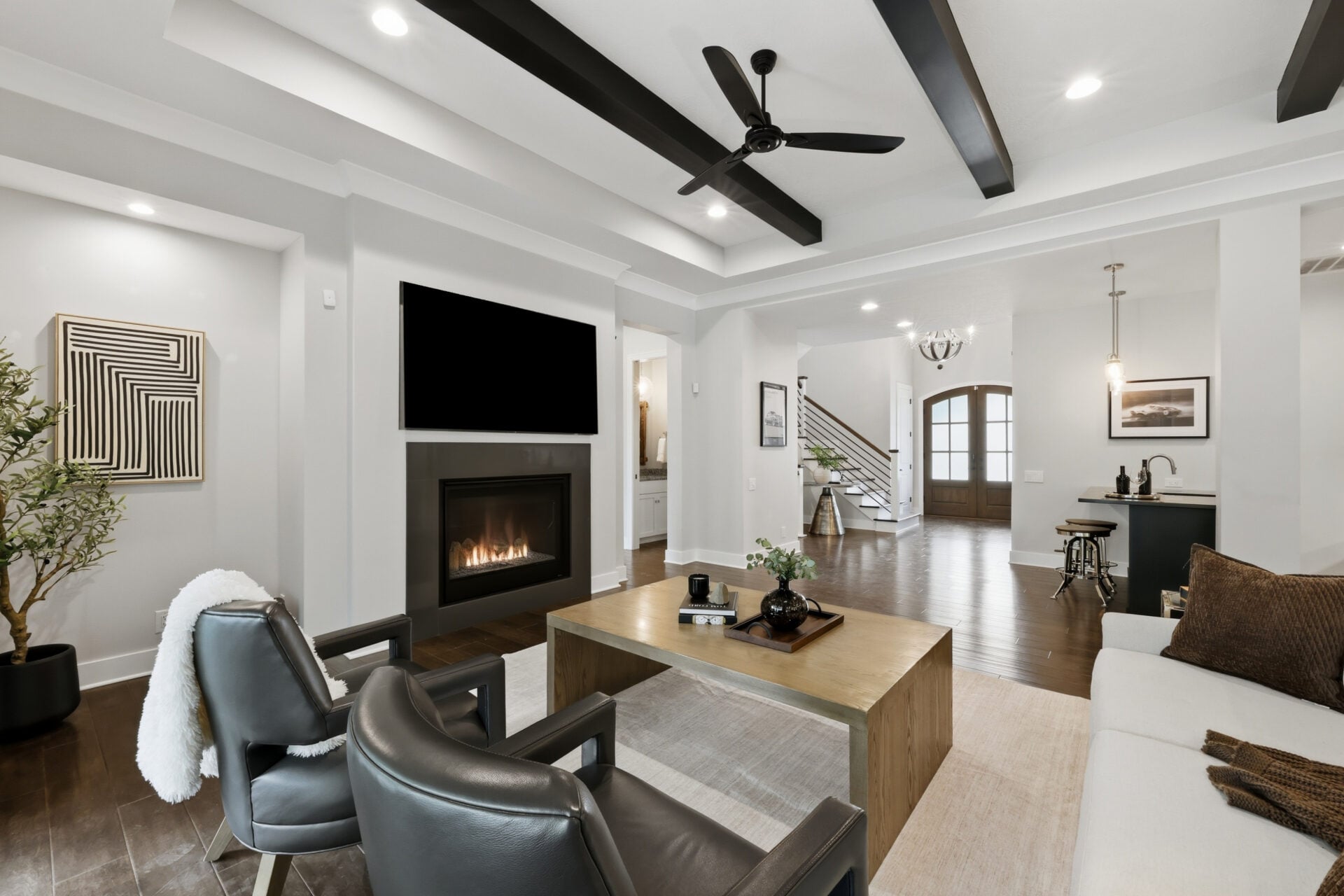 The living room is centered around a contemporary gas fireplace with a wall-mounted television above. 