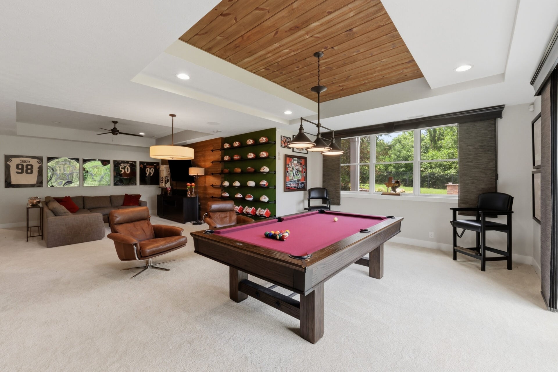Browns memorabilia, framed jerseys, and personal awards are integrated throughout the space before it opens into a larger recreation lounge centered around a pool table. 